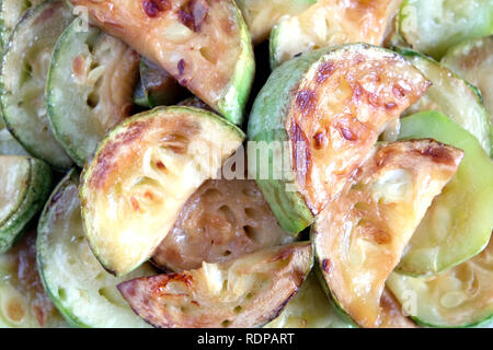 Molti fritti fette di zucchine sul round piastra bianca su sfondo bianco studio shot top view closeup Foto Stock