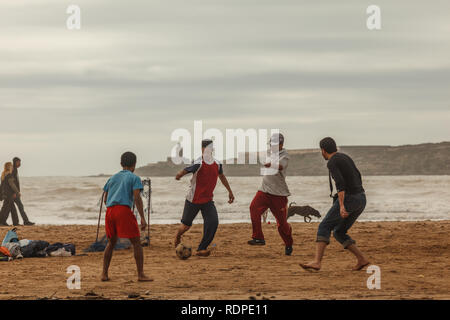 Gruppo di ragazzi marocchini che giocano a calcio, calcio sulla spiaggia Foto Stock