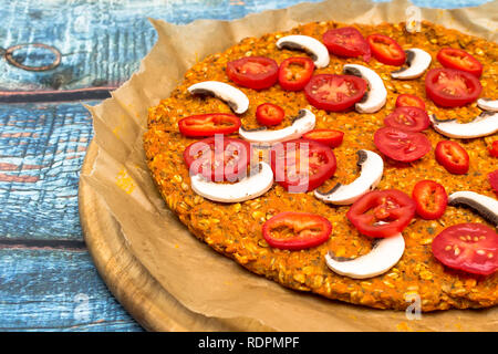Pizza con blat della patata dolce e semi di avena, guarnita con funghi, cipolle, mozzarella e pomodoro ciliegino Foto Stock