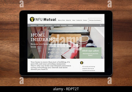 Il sito web della NFU mutuo è visto su un tablet iPad, il quale è appoggiato su un tavolo di legno (solo uso editoriale). Foto Stock