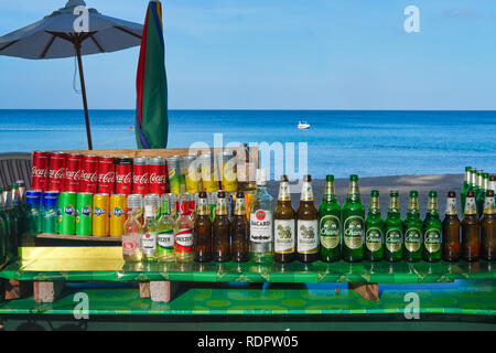 Le lattine di Coca Cola, altre bevande analcoliche e birra le bottiglie a una pressione di stallo sulla spiaggia, su una mattina presto a Bang Tao () Bangtao Beach, Bang Tao, Phuket, Tailandia Foto Stock