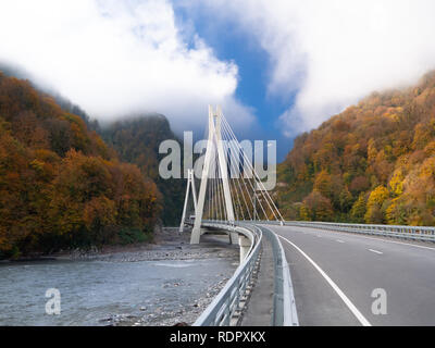 Splendido scenario autunnale con cavo-alloggiato ponte sopra una gola profonda nel Caucaso Foto Stock