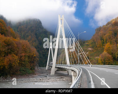 Splendido scenario autunnale con cavo-alloggiato ponte sopra una gola profonda nel Caucaso Foto Stock