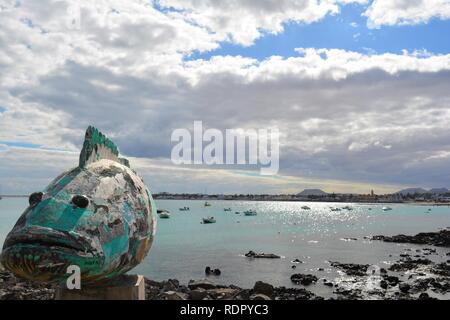 Un pesci colorati figura sul dock di Corralejo. Corralejo pier e brillante Oceano in background. Scenic sky. Fuerteventura, Spagna. Foto Stock