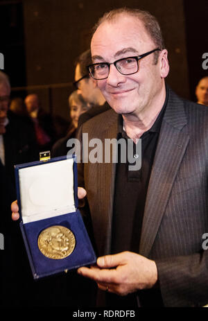 Mainz, Germania. 18 gennaio, 2019. Robert Menasse, scrittore austriaco e vincitore del 2019 Carl Zuckmayer medaglia, detiene il premio nelle sue mani. La medaglia è donato in memoria dello scrittore e drammaturgo che era nato a Nackenheim. Il premio riconosce i meriti per la lingua tedesca ed è presentato annualmente. Credito: Andreas Arnold/dpa/Alamy Live News Foto Stock