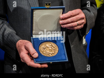 Mainz, Germania. 18 gennaio, 2019. Robert Menasse, scrittore austriaco e vincitore del 2019 Carl Zuckmayer medaglia, detiene il premio nelle sue mani. La medaglia è donato in memoria dello scrittore e drammaturgo che era nato a Nackenheim. Il premio riconosce i meriti per la lingua tedesca ed è presentato annualmente. Credito: Andreas Arnold/dpa/Alamy Live News Foto Stock