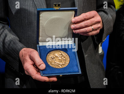 Mainz, Germania. 18 gennaio, 2019. Robert Menasse, scrittore austriaco e vincitore del 2019 Carl Zuckmayer medaglia, detiene il premio nelle sue mani. La medaglia è donato in memoria dello scrittore e drammaturgo che era nato a Nackenheim. Il premio riconosce i meriti per la lingua tedesca ed è presentato annualmente. Credito: Andreas Arnold/dpa/Alamy Live News Foto Stock