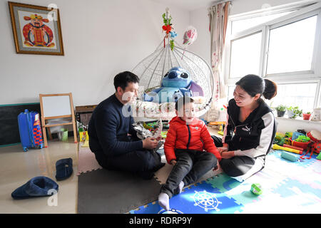 (190119) -- NANJING, Gennaio 19, 2019 (Xinhua) -- Xue Feng (R) e il marito gioca con il loro figlio zhuangzhuang a casa a Xuzhou, est cinese della provincia di Jiangsu, Gennaio 18, 2019. Xue Feng è un conduttore del treno della China Railway Shanghai Group Co. Ltd, il cui marito è un poliziotto. A causa dei loro posti di lavoro non possono accompagnare il loro figlio zhuangzhuang tutto il tempo. Ogni volta quando Xue Feng ha di uscire di casa per lavorare per un paio di giorni, Ella scriverà una scusa nota a zhuangzhuang per esprimere il suo rammarico. E ogni volta quando zhuangzhuang riceve una scusa nota da sua madre, egli sarà messo nel suo 'treas Foto Stock