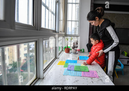 (190119) -- NANJING, Gennaio 19, 2019 (Xinhua) -- Xue Feng e suo figlio zhuangzhuang guardare la scusa di note a casa a Xuzhou, est cinese della provincia di Jiangsu, Gennaio 18, 2019. Xue Feng è un conduttore del treno della China Railway Shanghai Group Co. Ltd, il cui marito è un poliziotto. A causa dei loro posti di lavoro non possono accompagnare il loro figlio zhuangzhuang tutto il tempo. Ogni volta quando Xue Feng ha di uscire di casa per lavorare per un paio di giorni, Ella scriverà una scusa nota a zhuangzhuang per esprimere il suo rammarico. E ogni volta quando zhuangzhuang riceve una scusa nota da sua madre, egli sarà messo nel suo 'tesoro Foto Stock