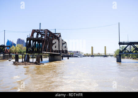 L'ho Street Bridge è una storica traliccio metallico ponte girevole situato sulla strada io nel Sacramento; il Tower Bridge e la skyline della citta' in backgroun Foto Stock