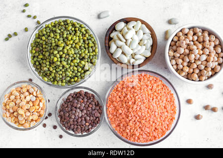 Cibo sano, dieta, nutrizione concetto, vegan fonte proteica. Assortimento di legumi colorati in ciotole, lenticchie, fagioli, ceci, mung, piselli Foto Stock