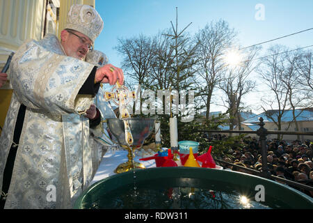 Uzhgorod, Ucraina - Jan 19, 2019: cattolica greca epifania cerimonia in cattedrale. sacerdote immergendo la croce nell'acqua Foto Stock