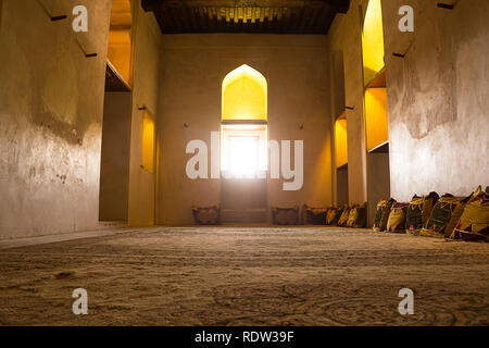 All'interno il Forte Jabrin camera con tappeti e cuscini e una finestra sul fondo (Oman) Foto Stock