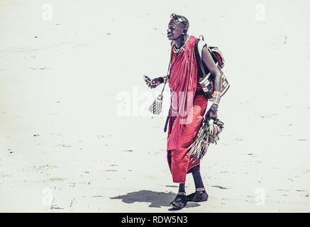 La spiaggia di Diani, KENYA - 14 ottobre 2018: Unindentified uomo africano indossando il tradizionale Masai vestiti sulla spiaggia di Diani, Kenya Foto Stock