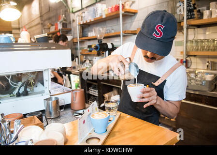 Barista in ballcap è il modello rilasciato. Il volo caffè Hangar è un cafe che serve la casa-di infuso di caffè, panini & luce mangia a 119 Dixon St in Te Ar Foto Stock