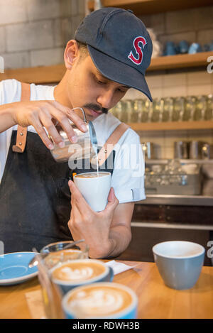 Barista in ballcap è il modello rilasciato. Il volo caffè Hangar è un cafe che serve la casa-di infuso di caffè, panini & luce mangia a 119 Dixon St in Te Ar Foto Stock