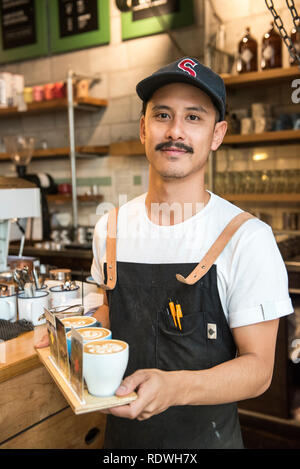 Barista in ballcap è il modello rilasciato. Il volo caffè Hangar è un cafe che serve la casa-di infuso di caffè, panini & luce mangia a 119 Dixon St in Te Ar Foto Stock