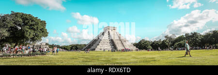 Chichen Itza piramide e elegante giovane donna camminare al tramonto con drammatica cielo velato in background Foto Stock