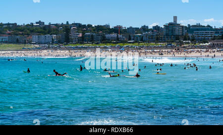 Surfers di prendere onde sulla spiaggia Bondi acqua in Sydney NSW Australia Foto Stock
