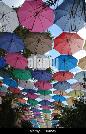 Multi-colore di ombrelli aperti offrono ombra per una stretta strada sulla parte turca di Nicosia, Cipro Foto Stock