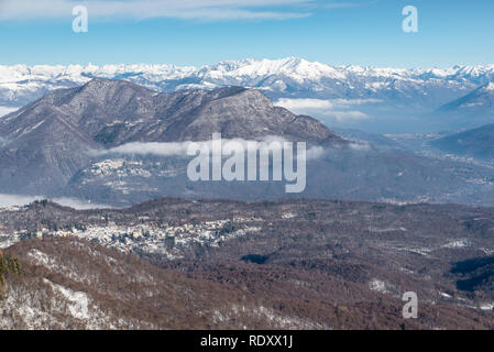 Alpi, Italia. Campo dei Fiori Parco Regionale in primo piano, con Castello Cabiaglio village, sullo sfondo la catena alpina. Foto Stock