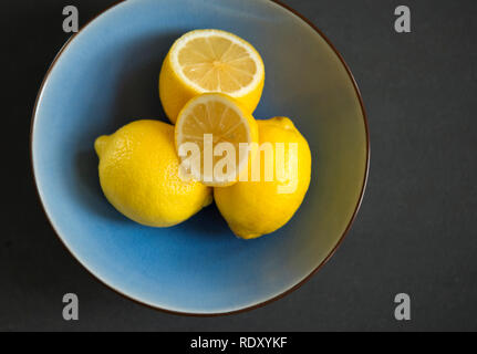 Tutto Limette fresche in un vaso blu su sfondo nero. Foto Stock