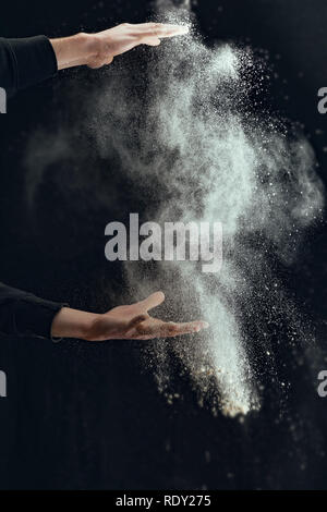 Mano umana attesa farina isolato su sfondo nero Foto Stock