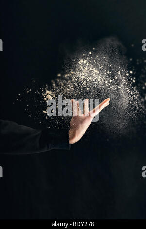 Mano umana attesa farina isolato su sfondo nero Foto Stock