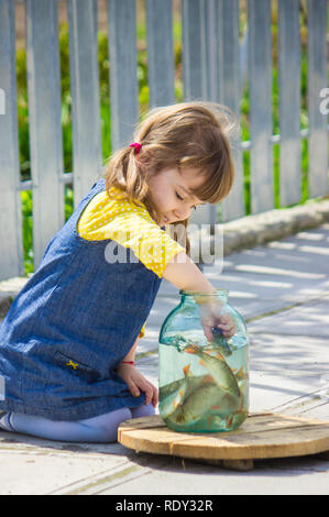 Un bambino sta giocando con il pesce in un possibile. Messa a fuoco selettiva. Foto Stock