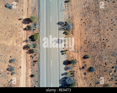 Nadir vista della strada sigillato in esecuzione attraverso il red colline di sabbia nel sud Outback australiano Foto Stock