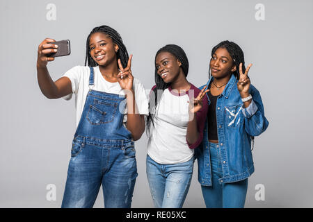 Ritratto di auto di affascinanti ragazze africane con trasmissione via IR di sorrisi selfie ripresa sulla fotocamera anteriore avente incontro online su sfondo bianco Foto Stock