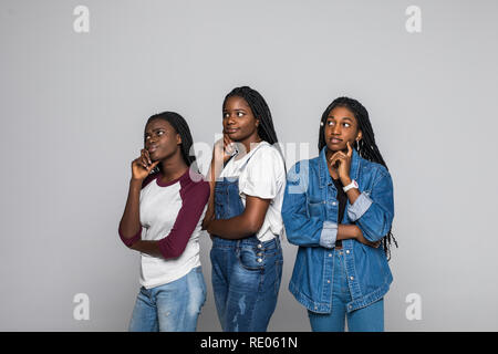 Ritratto di tre belle donne con mano sul mento pensando di domanda, pensieroso espressione bianco su sfondo isolato. Foto Stock