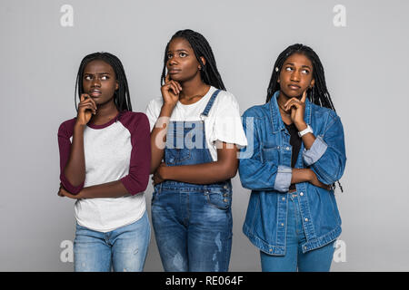 Ritratto di tre belle donne con mano sul mento pensando di domanda, pensieroso espressione bianco su sfondo isolato. Foto Stock