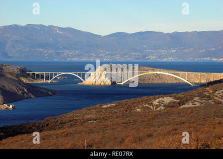 Croazia, Dalmazia, il ponte che collega la terraferma con l'isola di Krk. Ponte di Krk è un 1430 m di lunghezza cemento armato arch ponte che collega l'isola croata di Krk con la terraferma e il trasporto di oltre un milione di veicoli all'anno. Il più lungo del ponte di due archi è il secondo più lungo arco di calcestruzzo nel mondo e tra gli archi più lunga di qualsiasi costruzione. Il ponte è stato completato e aperto nel luglio 1980 e originariamente denominato Titov la maggior parte ("Tito's bridge') in onore del presidente Iugoslavo Josip Broz Tito, che era morta due mesi prima. Foto Stock