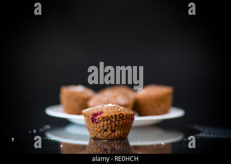 Fresche dolci muffin con frutti di bosco interno su nero Foto Stock