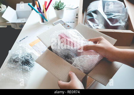 Shopping online concetti con femmina scatolare aperta, presenta alcuni prodotto nella sua mano.Ecommerce,Spedizioni servizio consegna.business sul mercato al dettaglio Foto Stock