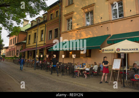 Cracovia in Polonia - 9 luglio 2018. Una cameriera attende per più clienti al di fuori di un ristorante nel popolare quartiere di Cracovia di Kazimierz Foto Stock