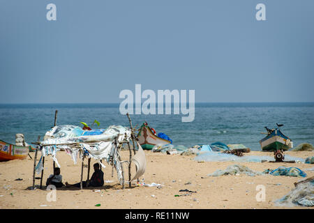 Pescatori tende di fortuna e reti sulla spiaggia di Marina sulla baia del Bengala vicino a Chennai, India Foto Stock