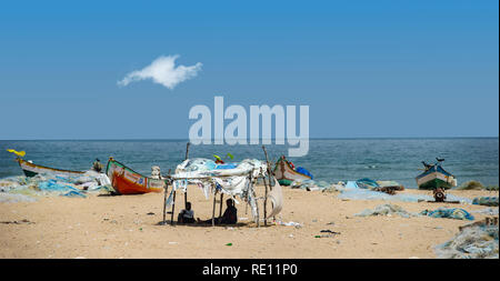 Pescatori tende di fortuna e reti sulla spiaggia di Marina sulla baia del Bengala vicino a Chennai, India Foto Stock