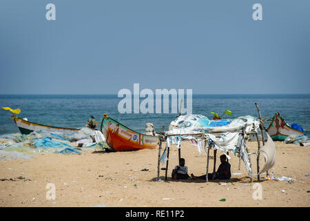 Pescatori tende di fortuna e reti sulla spiaggia di Marina sulla baia del Bengala vicino a Chennai, India Foto Stock