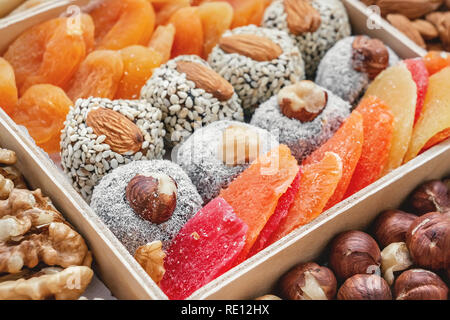 I dolci orientali e la frutta secca e i dadi in una scatola di legno. Sfondo. Sano cibo vegan. Alimenti naturali. Foto Stock