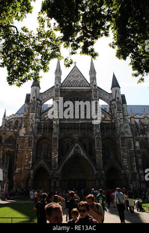 I turisti in piedi di fronte alla chiesa Collegiata di San Pietro a Westminster (l'Abbazia di Westminster) a Londra, Regno Unito, su una bella giornata d'estate Foto Stock