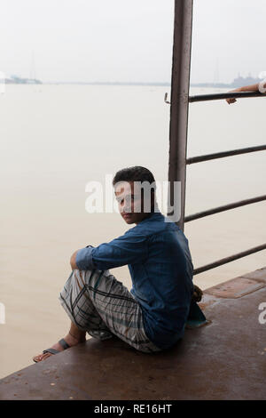 Kolkata / India - Agosto 2015: un giovane uomo seduto sul traghetto che collega Kolkata con quella di Howrah. Foto Stock