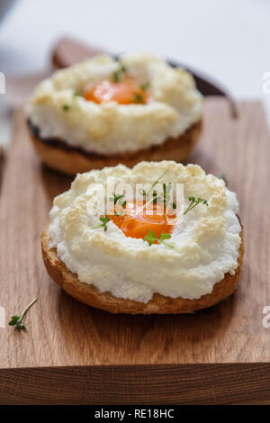 Uova orsini con verdi su sfondo di legno Foto Stock