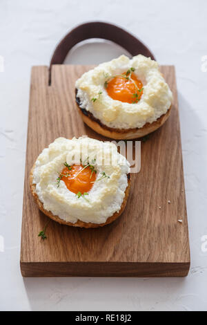 Uova orsini con verdi su sfondo di legno Foto Stock