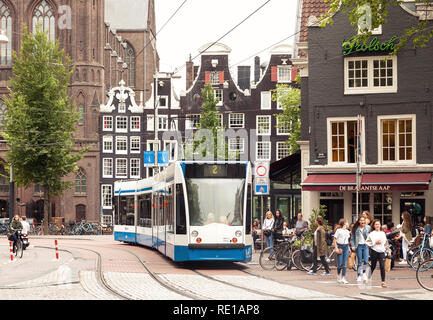 Amsterdam city center view in Paesi Bassi, città vecchia scena di strada con i mezzi di trasporto pubblico il tram che passa da Foto Stock