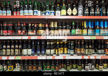 Varietà di belga birre artigianali per la vendita in un negozio di bottiglie di marca su shop espositore in un supermercato a Bruges Foto Stock