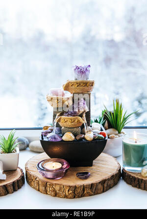 Spirituale rilassante Feng Shui altare con la natura, di acqua e di elemento fuoco. Il piano portapaziente piccola fontana elettrica con acqua versando tazze. Simbolo di ricchezza. Foto Stock