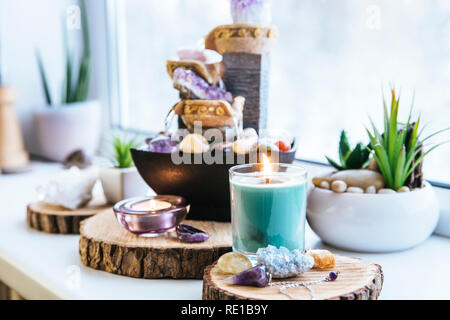 Spirituale rilassante Feng Shui altare con la natura, di acqua e di elemento fuoco. Il piano portapaziente piccola fontana elettrica con acqua versando tazze. Simbolo di ricchezza. Foto Stock