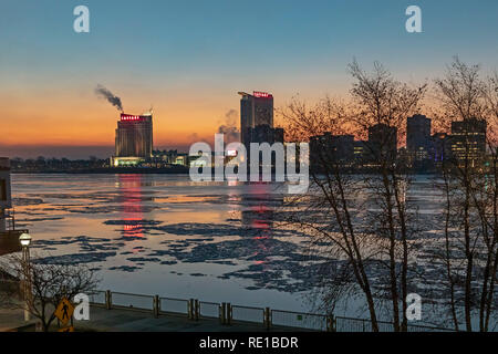 Detroit, Michigan - Il Gelido Fiume Detroit prima dell'alba, la separazione di Detroit e, attraverso il fiume, Windsor, Ontario in Canada. Caesars casinò e hotel Foto Stock